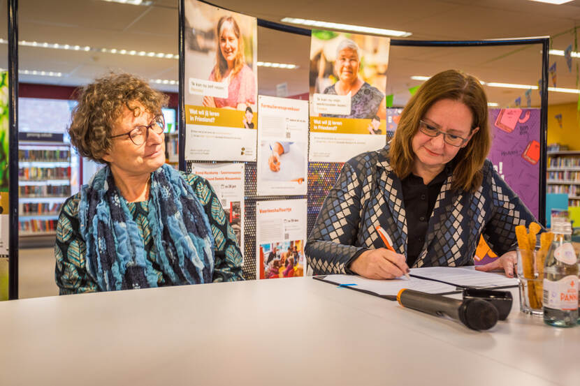 Staatssecretaris Aukje de Vries ondertekent de samenwerkingsovereenkomst. KB-directeur Lily Knibbeler kijkt toe.